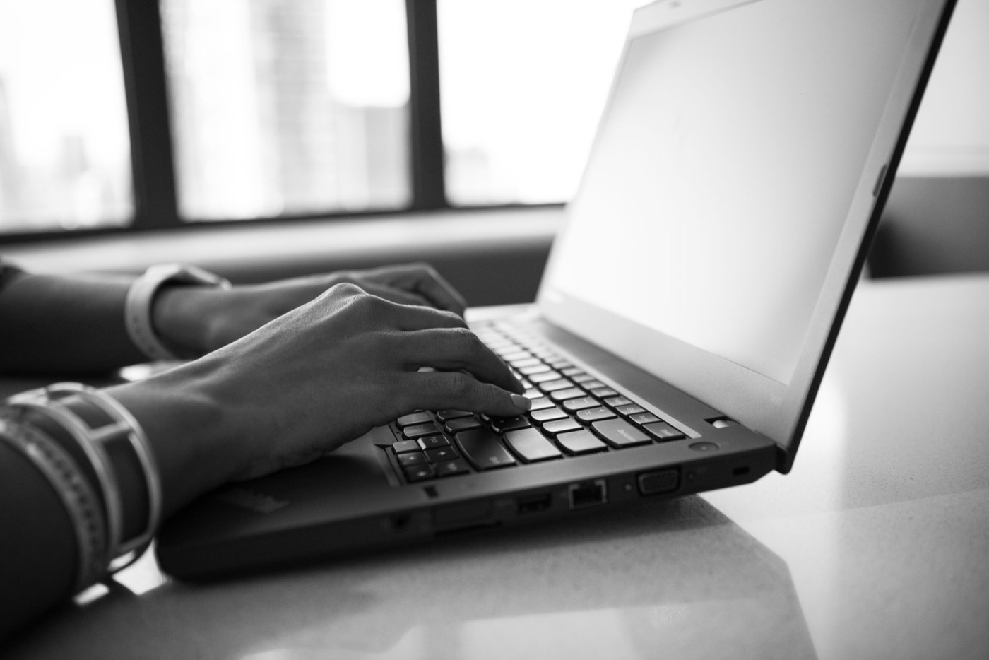 Mains sur le clavier d’un ordinateur portable