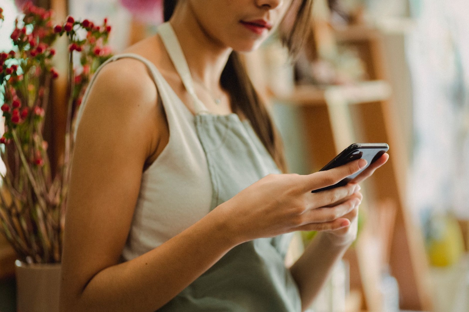 Une commerçante consulte les avis de sa boutique sur son téléphone