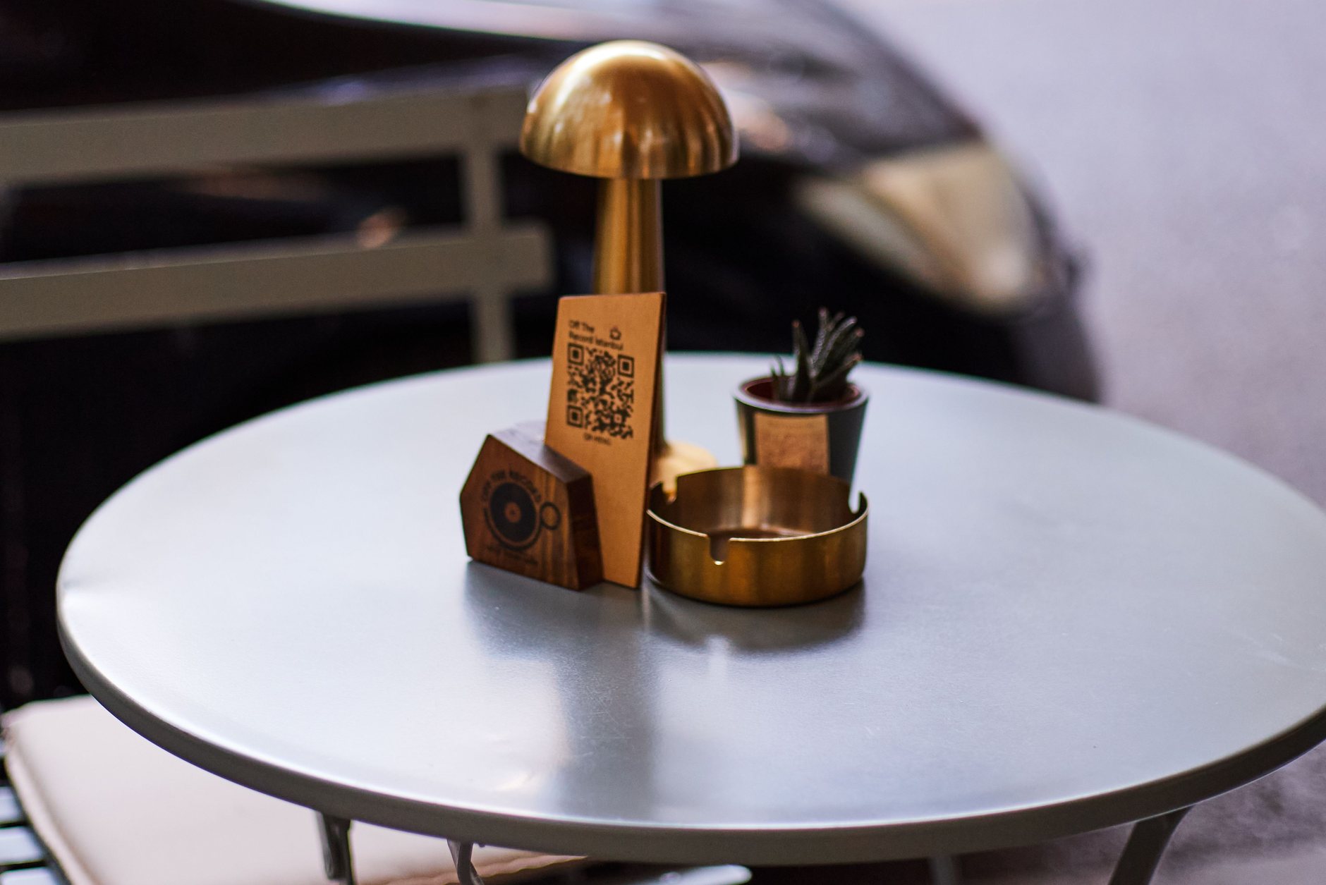 chevalet en bois portant un QR code posé sur une table ronde de café en terrasse