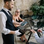 Avis Google restaurant : serveur présentant le terminal de paiement à un couple attablé