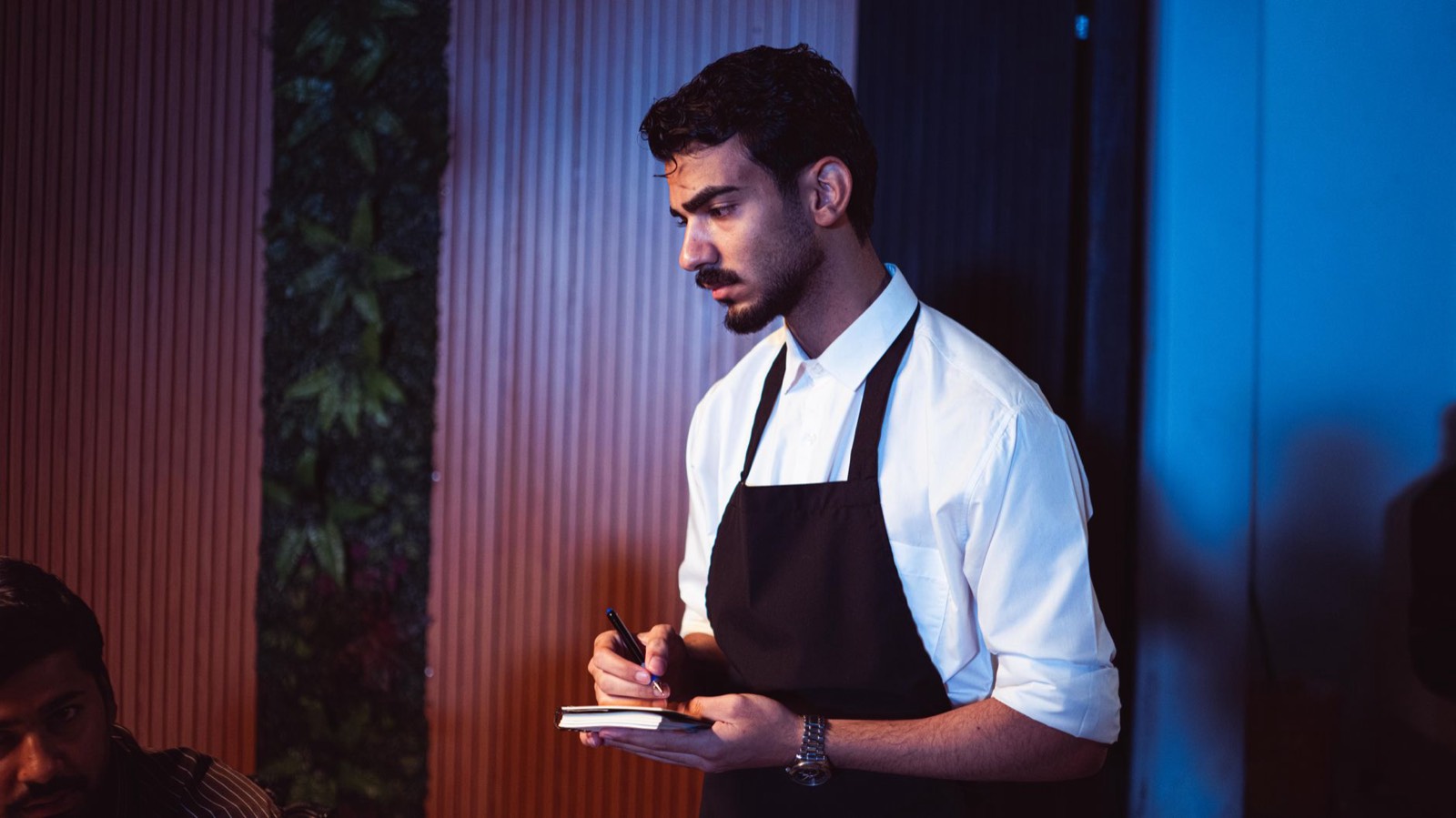 Serveur prenant une commande sur tablette à table dans un restaurant